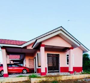 a red car parked in front of a house at Bushriah Homestay Pendang in Pendang