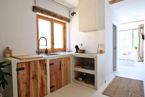 a kitchen with wooden cabinets and a sink at Apartamentos Nomad Home in Huerta de Vero