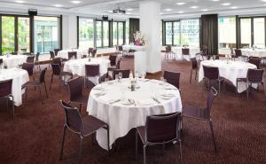 a room with white tables and chairs and windows at Crowne Plaza Amsterdam - South, an IHG Hotel in Amsterdam