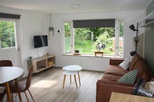 una sala de estar con un sofá y una mesa en Erfgoed de Boemerang - Chalets, en Meppen