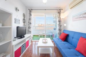 Una sala de estar con un sofá azul y un televisor. en Apartamento playa Canet, en Canet de Berenguer 23 fotos más