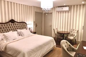 a bedroom with a bed and a table and chairs at Daara Transamerica Collection Gramado in Gramado