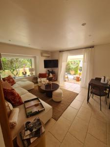 un soggiorno con divano e tavolo di Appartement luxueux à 100m de la plage a Saint-Tropez