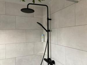 eine Dusche im Bad mit einer weißen Wand in der Unterkunft Ferienwohnung Heideweg in Schneverdingen + 27 Fotos