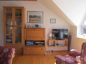 ein Wohnzimmer mit einem Entertainment-Center und einem TV in der Unterkunft Ferienwohnung Heideweg in Schneverdingen