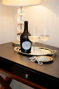 a table with two glasses and a bottle of wine at Hotel Palazzo Cavalieri in Syracuse