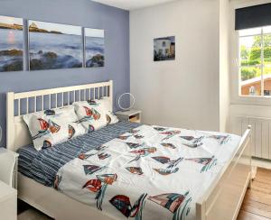 een slaapkamer met een bed met een witte sprei met boten erop bij Maison de 2 chambres avec jardin clos et wifi a Sainte Anne d'Auray in Sainte Anne d'Auray 