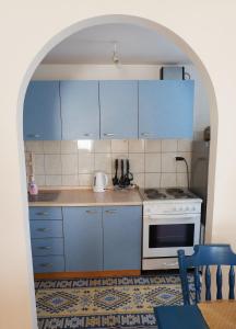 uma cozinha com armários azuis e um fogão branco em Bosnian Mountain Retreat em Prijedor