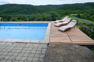 um grupo de espreguiçadeiras ao lado de uma piscina em Bosnian Mountain Retreat em Prijedor
