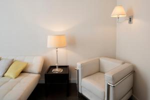 a living room with a couch and a chair and a lamp at Hotel Palazzo Cavalieri in Syracuse