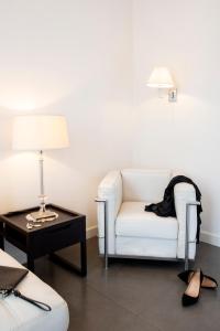 a living room with a white couch and a table with a lamp at Hotel Palazzo Cavalieri in Syracuse