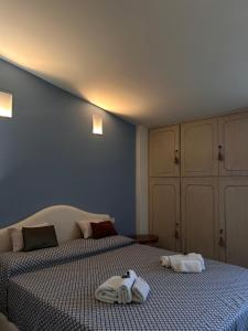 a bedroom with two beds with towels and a cat on them at SUN Holiday in Salò