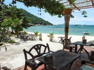eine Gruppe von Tischen und Stühlen am Strand in der Unterkunft 3 bedrooms villa at Tambon Mae Nam 500 m away from the beach with sea view private pool and furnished terrace in Ban Bang Po