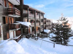 een met sneeuw bedekt balkon van een gebouw met een kerstboom bij Appartement de 2 chambres avec terrasse amenagee a La plagne in La Plagne
