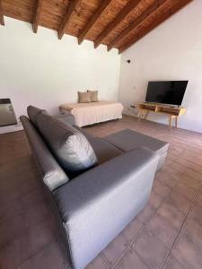 un soggiorno con divano e TV a schermo piatto di Casa Los Ciruelos - Chacras de Coria a Mayor Drumond Altre 9 foto