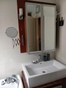 a bathroom with a white sink and a mirror at Galeria Villa in Veszprém
