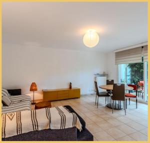 un salon avec un lit et une table dans l'établissement Chez Marta I T3 Avec Jardin I Annemasse, à Annemasse