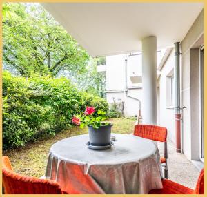 une table avec une plante en pot sur une terrasse dans l'établissement Chez Marta I T3 Avec Jardin I Annemasse, à Annemasse
