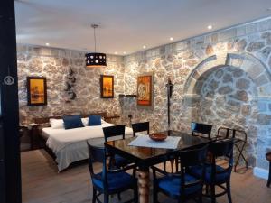 a bedroom with a bed and a table and chairs at Rahoni Park & Suites in Dhërmi