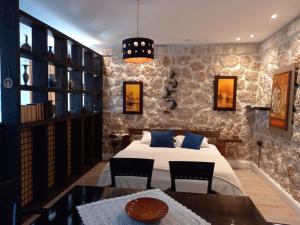1 dormitorio con 1 cama, mesa y sillas en Rahoni Park & Suites, en Dhërmi