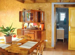 ein Esszimmer mit einem Holztisch und einer Küche in der Unterkunft Maison de 2 chambres avec vue sur la mer jardin clos et wifi a Saint Paul a 7 km de la plage in Saint-Paul