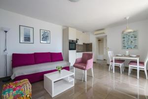 a living room with a purple couch and a table at Yasmin in Brseč