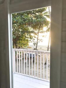 a view of the beach from a porch with an open window at Appartement d'une chambre a Le Carbet a 1 m de la plage avec vue sur la mer jardin clos et wifi in Le Carbet
