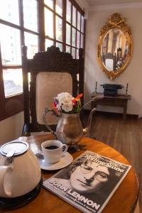a table with a tea pot and a vase with flowers on it at Anami Hotel Boutique in La Paz