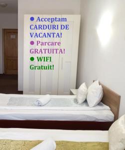 um quarto com uma cama com uma placa na parede em RHC Royal Hotel em Oradea