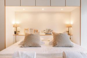 a bedroom with a white bed with two pillows at Huswell - Apartment on top location in Knokke with parking in Knokke-Heist