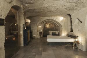Habitación con cama blanca en un edificio de piedra en Aque cave en Matera
