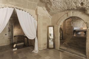 um quarto com uma cortina branca num edifício em Aque cave em Matera