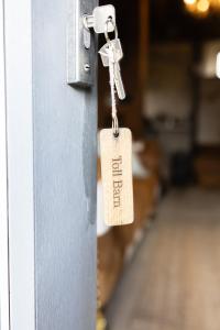 una etiqueta pegada a una puerta con una llave en Toll Barn, St Osyth Priory en Colchester