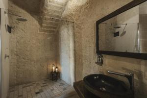 baño con lavabo negro y espejo en Aque cave en Matera