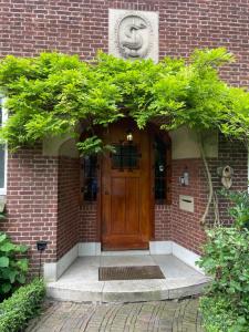 una porta d'ingresso di un edificio di mattoni con una statua sopra. di B&B Bommelsteijn a Dordrecht