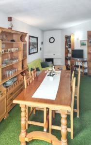 uma sala de jantar com uma mesa de madeira e cadeiras em One bedroom apartement with shared pool sauna and terrace at La Pinilla em La Pinilla