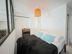 1 dormitorio con 1 cama con almohadas azules y lámpara en Ravissant T1 au bord de l'eau Juan Les Pins, en Antibes