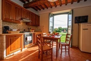 cocina con mesa, sillas y nevera en Casa Vacanze La Fiorita, en Terontola