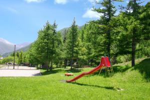 アルヴィユーにあるAppartement de 3 chambres avec jardin clos et wifi a Le coin a 1 km des pistesの緑地の赤い滑り台付き遊び場