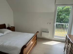 a bedroom with a bed and a large window at L escapade du Cap in Barneville-Carteret