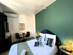 - une chambre dotée d'un lit avec un mur vert dans l'établissement Gabrielle hôtel, à Aiguines
