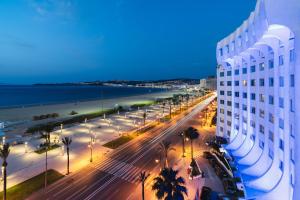 a view of a building and a beach at night at Kenzi Solazur in Tangier