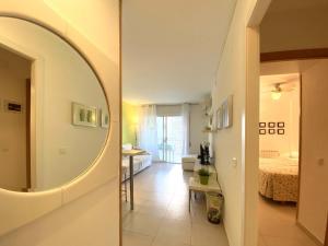 Una sala de estar con espejo y un dormitorio. en Cambrils PORT 11003, en Cambrils