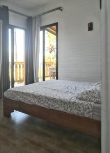 a bedroom with a large bed with a window at Chalet de 2 chambres avec vue sur la mer jardin clos et wifi a Saint Leu in Saint-Leu