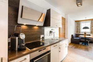 een keuken met een wastafel en een fornuis top oven bij Apartment S in Ehrwald