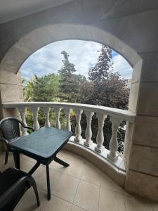 a balcony with a table and a chair and a window at Charming Two-Bedroom Apartment in Villa Roma in Burgas City
