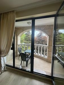 a room with a balcony with a table and chairs at Charming Two-Bedroom Apartment in Villa Roma in Burgas City