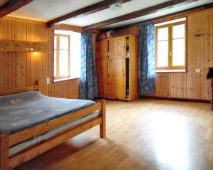 1 dormitorio con 1 cama con paredes y ventanas de madera en Maison d'une chambre avec jardin amenage et wifi a Septmoncel en Septmoncel
