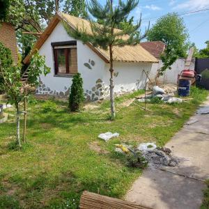 una pequeña casa blanca con un árbol en el patio en Kuća za odmor ''S'' en Mladenovo