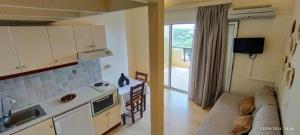 eine Küche und ein Wohnzimmer mit einem Sofa in der Unterkunft Lofos Apartments in Prínos